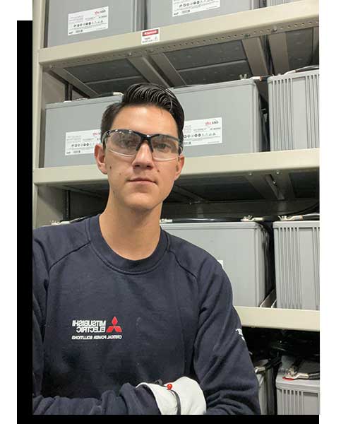 Field Technician on site in front of batteries.