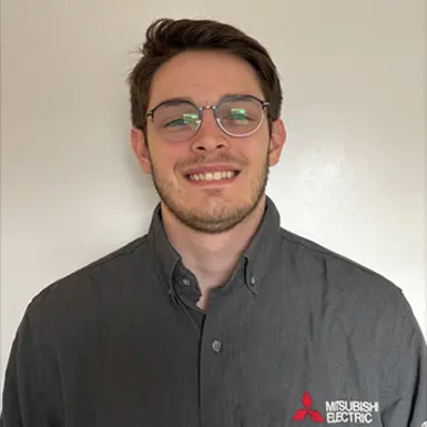 Man in gray shirt and glasses with black circuit background.