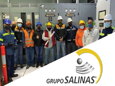 Group picture in electrical room with Grupo Salinas logo.